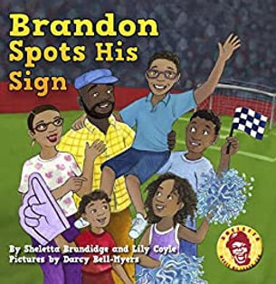 Cover of Brandon Spots His Sign, showing a boy lifted up by his family at a race track.